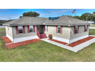 Single-story home with red accents and a spacious yard at 3610 Old Berkley Rd, Auburndale, FL 33823