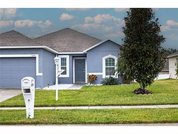 Curb appeal abounds in this charming one-story home featuring a two-car garage and well-manicured lawn at 6144 Forest Ridge Way, Winter Haven, FL 33881