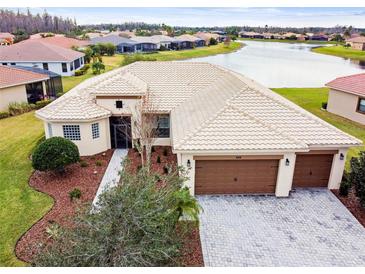 Single-story home with tile roof, two-car garage, and lake view at 644 San Raphael St, Kissimmee, FL 34759