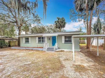 Newly renovated home with teal door and carport at 645 King St, Eustis, FL 32726