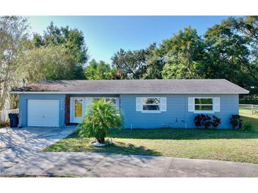 Cute ranch home with a grey exterior, nicely landscaped yard, and driveway at 2219 Pilaklakaha Ave, Auburndale, FL 33823