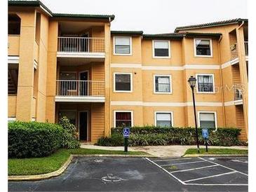 A condo building featuring an accessible parking spot, shrubbery, and multiple balconies at 3004 Parkway Blvd # 208, Kissimmee, FL 34747