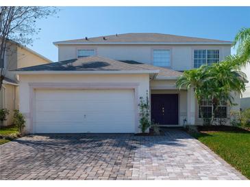 Charming two-story home with a brick driveway, attached garage, and well-manicured lawn at 4626 Cumbrian Lakes Dr, Kissimmee, FL 34746
