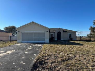 One-story house with a garage and a spacious yard at 869 Colville Dr, Kissimmee, FL 34759