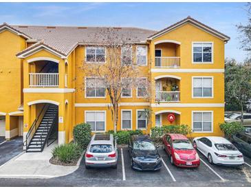 Exterior view of a yellow building with parking and landscaping at 8848 Villa View # 106, Orlando, FL 32821