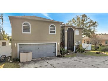 Two story home featuring a two-car garage, neutral color scheme, and well-maintained landscaping at 212 Rontunda Dr, Kissimmee, FL 34758