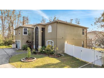 Charming two-story home featuring a well-manicured lawn and a white fence at 212 Rontunda Dr, Kissimmee, FL 34758