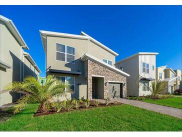 Modern two-story home with stone accents and landscaped lawn at 2746 Bookmark Dr, Kissimmee, FL 34746
