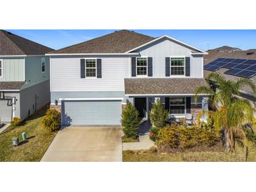 Two-story house with gray siding, stone accents, and a two-car garage at 583 Taft Dr, Davenport, FL 33837