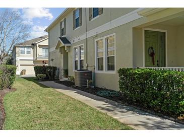 Exterior view of townhome with walkway, landscaping, and AC unit at 7137 Harmony Square Dr # 31A, Harmony, FL 34773