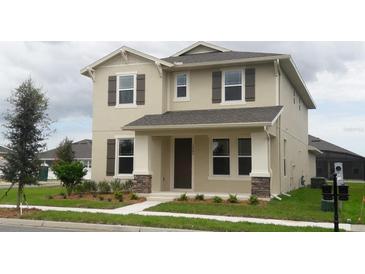 Two-story house with neutral siding, shutters, and landscaping at 15043 Pigeon Plum Ln, Winter Garden, FL 34787