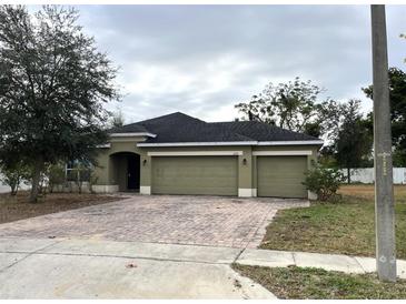 Newly constructed home with a two-car garage and a well-maintained lawn at 228 Whispering Pines Way, Davenport, FL 33837