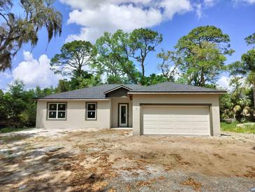 Charming single-story home with a two-car garage and neutral color palette on a sunny day at 2531 Buena Vista Dr, Deland, FL 32724