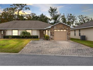 Charming single-story home featuring a stone accent garage and patterned brick driveway at 2717 Shelby Ruth Pl, St Cloud, FL 34769