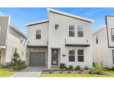 Modern two-story house with gray garage door and stone accents at 4370 Rhyme St, Kissimmee, FL 34746