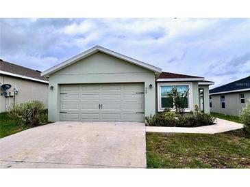 One-story home with attached garage and landscaped front yard at 505 Pentas Ln, Haines City, FL 33844