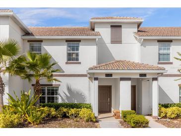 Two-story townhome with attractive landscaping and double-door entry at 8985 Stinger Dr, Davenport, FL 33896