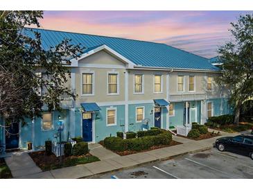 Front view of charming townhouses with blue roofs and light-colored siding at 2015 Grand Oak Dr, Kissimmee, FL 34744