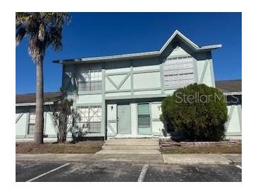 Two-story townhouse with light green exterior and landscaping at 3209 Windover Ave, Kissimmee, FL 34741
