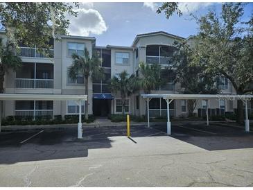 Exterior view of a condo building with parking at 3341 Whitestone Cir # 205, Kissimmee, FL 34741