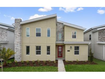Two-story house with a modern design, red door, and landscaping at 4575 Narrative Ln, Kissimmee, FL 34746