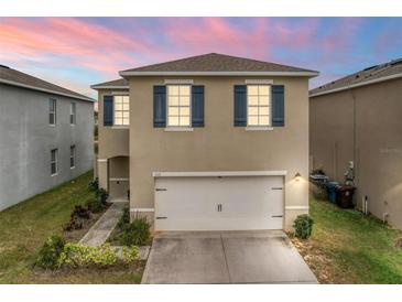 Two-story house with a white garage door and blue shutters at 113 Eagleview Loop, Davenport, FL 33837