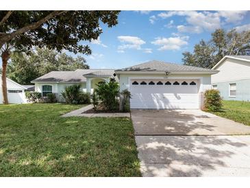 House exterior with a two-car garage and well-maintained lawn at 1608 Nectarine Trl, Clermont, FL 34714