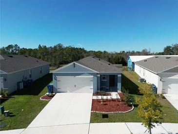 Newly constructed home with a two-car garage and landscaped front yard at 1657 Rosydale Cir, Davenport, FL 33837