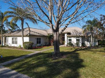Single-story home with metal roof, landscaped lawn, and walkway at 3228 Abalone Blvd, Orlando, FL 32833