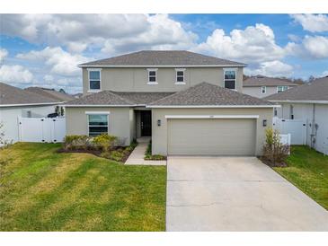 Two-story house with a two-car garage and manicured lawn at 332 Pink Ibis Bnd, St Cloud, FL 34772