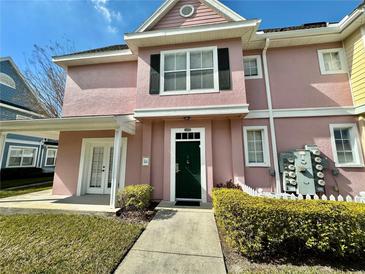 Pink two-story townhome with green door and well-manicured landscaping at 4006 San Gallo Dr # 108, Kissimmee, FL 34741