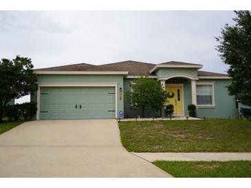 One-story house with a two-car garage and a yellow front door at 1028 Merrimack Blvd, Davenport, FL 33837
