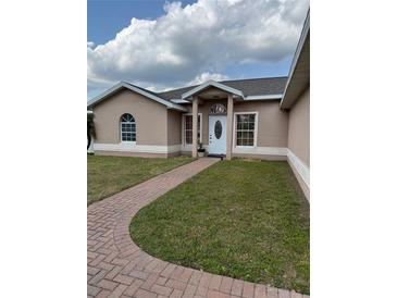 Charming single-story home with well-maintained lawn and brick walkway leading to front door at 149 Birmingham Dr, Kissimmee, FL 34758