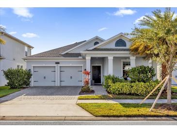 Two-story home with gray exterior, two-car garage, and landscaped front yard at 4540 Sequel Rd, Kissimmee, FL 34746