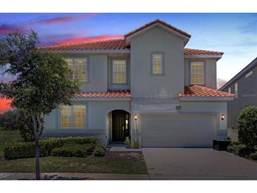 Two-story house with a red tile roof, large garage, and landscaping at 6052 Broad Oak Dr, Davenport, FL 33837