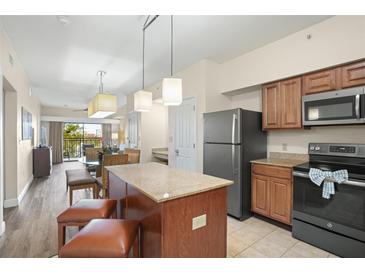 Modern kitchen with stainless steel appliances and an island at 12538 Floridays Resort Dr # 411, Orlando, FL 32821