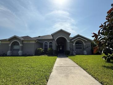 Charming single-story home with manicured lawn, arched entryway, and classic architectural details at 1534 Gants Cir, Kissimmee, FL 34744