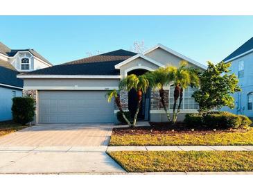 One-story home with gray siding, herringbone driveway, and palm trees at 2304 Cedar Garden Dr, Orlando, FL 32824