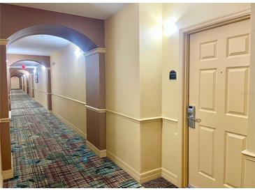 Long hallway featuring decorative archways, wall accents and patterned carpeting at 8100 Poinciana Blvd # 2405, Orlando, FL 32821
