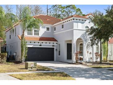 Two-story house with gray exterior, tile roof, and a two-car garage at 901 Marcello Blvd, Kissimmee, FL 34746