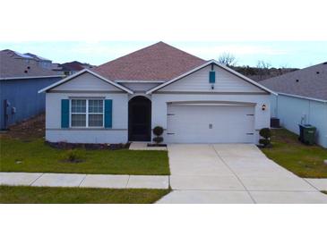 One-story house with a two-car garage and landscaped lawn at 1057 Cambridge Dr, Winter Haven, FL 33881