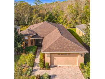 Beautiful home features a well-manicured lawn, paver driveway, and charming landscaping at 203 Los Gatos Pl, Poinciana, FL 34759