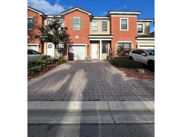 Two-story townhome with a two-car garage and brick paver driveway at 3459 Allegra Cir, St Cloud, FL 34772