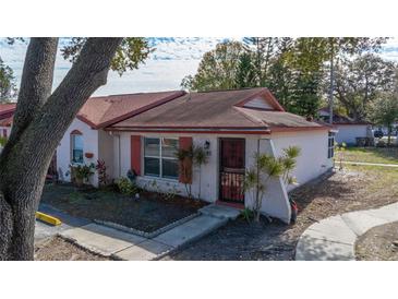 Cozy single-story home featuring mature trees, red shutters, and well-maintained landscaping at 46 W Marbrisa Way, Kissimmee, FL 34743