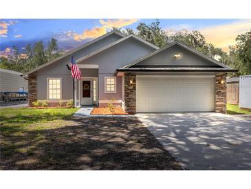 Two-story house with gray siding, stone accents, and a two-car garage at 4755 Oakwood Dr, St Cloud, FL 34772