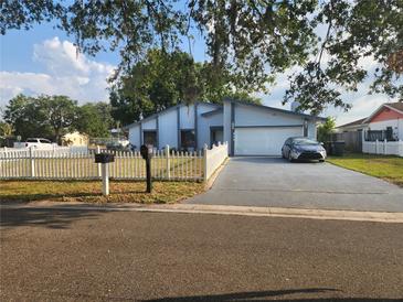 Charming single-Gathering home with a manicured lawn, white picket fence, and a spacious two-car garage at 602 Caddy Dr, Kissimmee, FL 34759