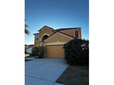 Two-story house with attached garage and landscaping at 109 Miro Dr, Davenport, FL 33837