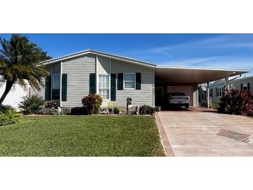 Single-wide manufactured home with carport and landscaped lawn at 1296 Skyline Dr, Tavares, FL 32778