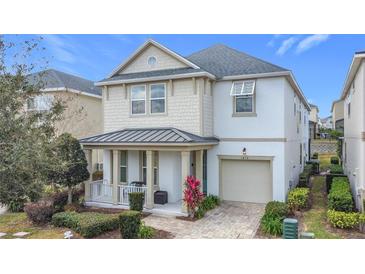 Two-story house with a gray roof, light beige and white siding, and a two-car garage at 1812 Sandy Park Trl, Kissimmee, FL 34747