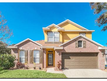 Brick two-story house with a two-car garage and landscaping at 223 Largovista Dr, Oakland, FL 34787